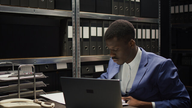 While caucasian inspector does research, focused African American detective examines evidence and deciphers the clues.