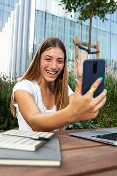 Woman making video call with phone outdoors laughing