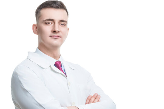 One Positive Confident Professional Male GP Doctor Posing in Doctor's Smock With Hands Folded in Front of Chest Looking Straight Against Pure White
