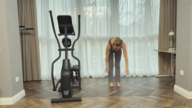 Woman synchronizes breath with movement raising arms up and bending forward. Calm home routine combining breathing, stretching and mindful exercise.