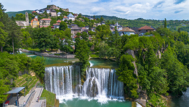 Scenic Aerial View of Pliva Waterfall and Medieval Jajce Fortress under Blue Sky in Bosnia