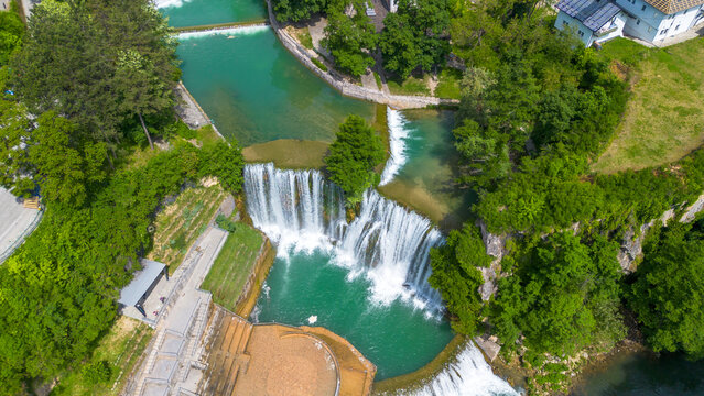 Scenic Aerial View of Pliva Waterfall and Medieval Jajce Fortress under Blue Sky in Bosnia
