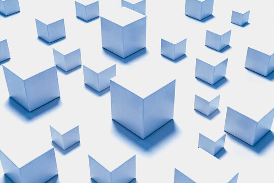 A collection of three-dimensional white cubes of varying sizes arranged in a minimalist layout on a plain white surface, forming a clean geometric composition.