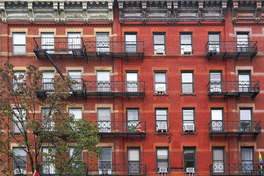 Old Manhattan apartment building with fire escape and ornate roof cornice