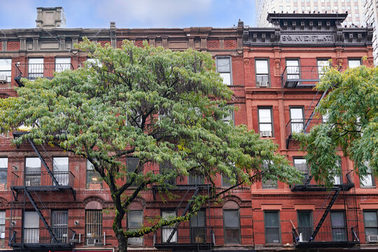 Old Manhattan apartment building with fire escape and ornate roof cornice