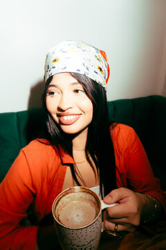 Young latina woman enjoying warm drink smiling concept