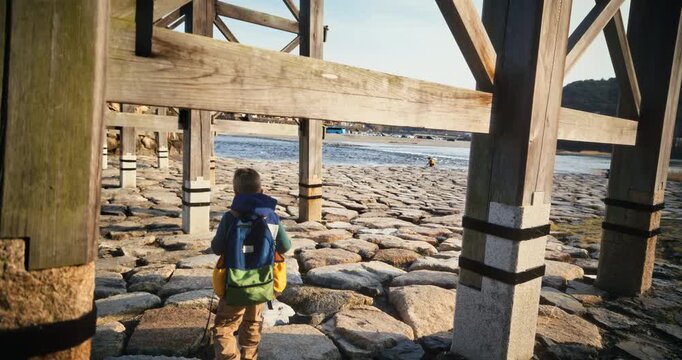 Child Walks Under Historic Wooden Bridge Cobblestone Riverbank Japan