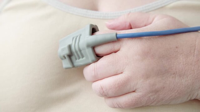 pulse oximeter attached patient's finger, fitness tracker, measuring oxygen saturation, medical device used to monitor oxygen levels in blood