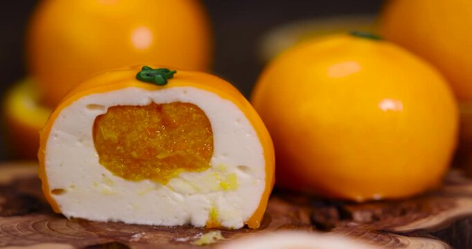 The orange Dessert with  layers, an exquisite pastry dessert with imitation orange peel and juicy core under soft studio light with an authentic look and texture.