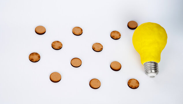 A light bulb beside scattered round wooden pieces, representing creative connection, idea mapping and strategic problem solving.
