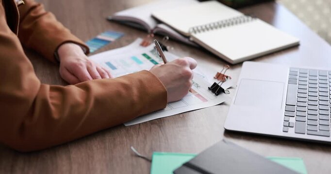 Woman with monthly planner at wooden desk, closeup
