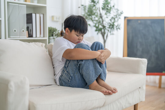 Bullying awareness, sad asian boy sitting alone hugging knees, child mental health, psychological trauma, emotional distress, depression symptom, social isolation, school violence and silent victim