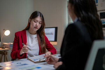 Fototapeta premium Business Meeting Between Two Women Discussing Documents in Office Setting