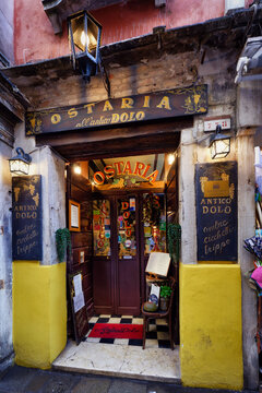 Venice, Italy June 01 2026: Charming facade of the historic Ostaria all'antico Dolo restaurant in Venice, featuring yellow walls, vintage signs, and lanterns