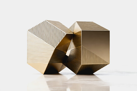 Two polished golden interconnected geometric polyhedrons with linear textures, displayed on a white reflective surface as a modern abstract art piece.