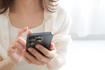 スマホでオンラインサービスを利用する女性 © webbiz