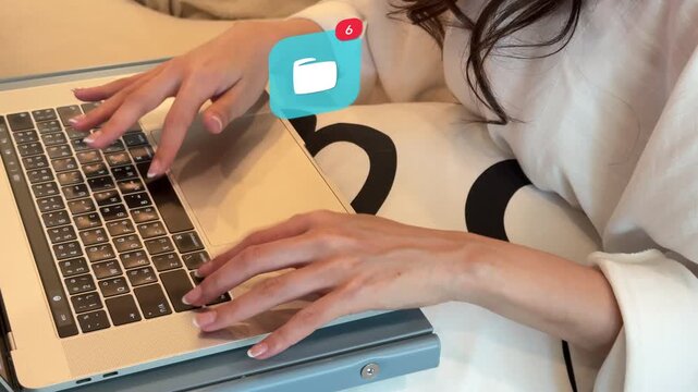 High angle close up of a young East Asian woman organizing files on her laptop computer, surrounded by a 3D tracked virtual data folder notification alert icon.