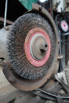Close-up of a worn wire wheel brush on a grinding machine