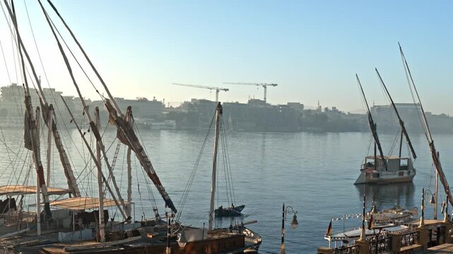 A scenic morning view looking across the calm waters of the Nile River in Luxor, Egypt.