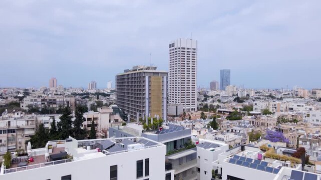 Solar panels and blooming jacaranda trees dot Tel Aviv's sunlit rooftops