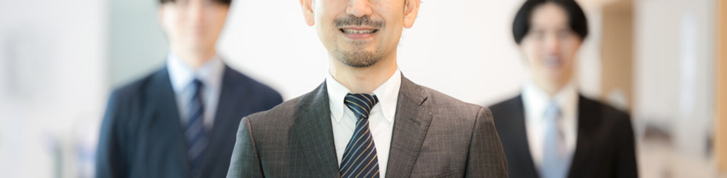 経験豊富な管理職を中心に横並びの経営者や社長と組織のカメラ目線の男性ビジネスチームの　士業やコンサルタントなどの仕事のイメージ　顔無しのバナー