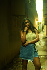 Naklejka premium Young Woman in Casual Summer Outfit Posing Against Urban Wall