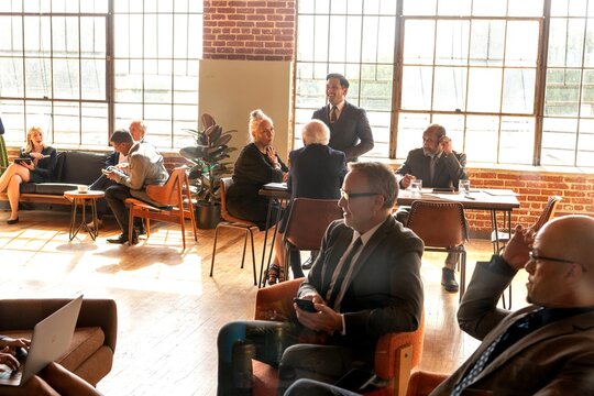 Diverse business professionals networking in a sunlit modern office lounge