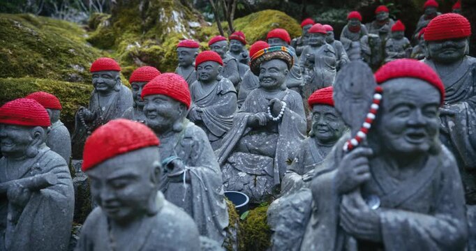 Many Little Stone Rakan Statues with Red Knit Caps at Japanese Temple - Steady Cam