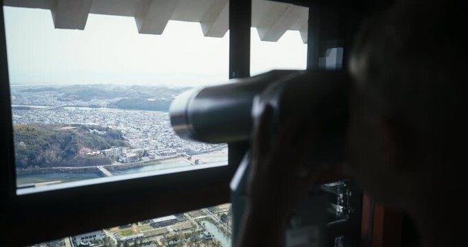 Silhouette of Kid Using Coin Operated Binoculars at Observation Deck In Hiroshima, Japan
