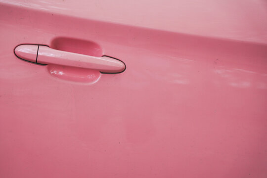 Close-up view of pink car door handle for automotive detail