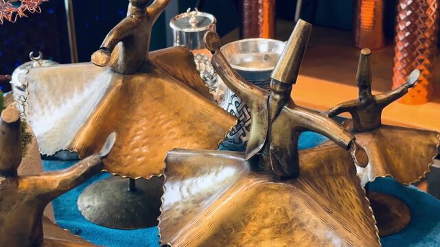 Miniature copper whirling dervish figurines on display by oriental window lattice. Traditional sufi dance statues, authentic middle eastern handicraft, turkish culture heritage and faith concept.