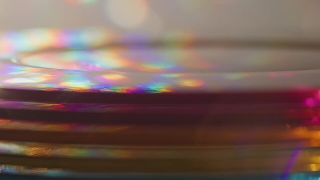 Stacked discs shimmer with rainbow light, diffraction reveals hidden beauty in everyday optical surfaces.