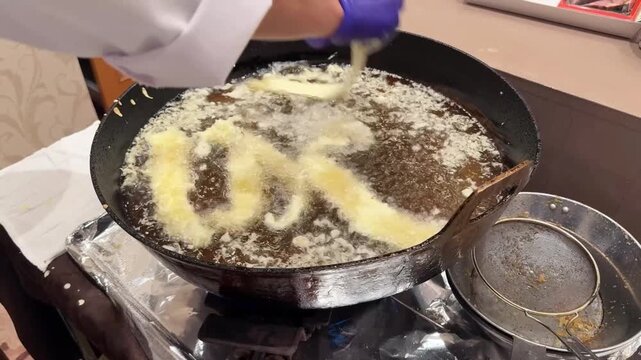 穴子の一本揚げを大鍋の油で揚げる