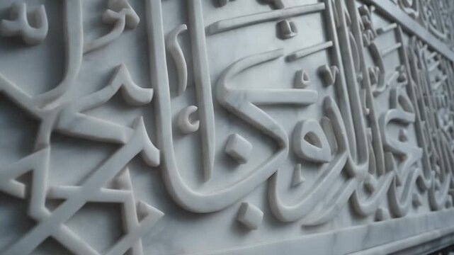 Intricate white marble carving with geometric patterns and Arabic calligraphy, close-up view