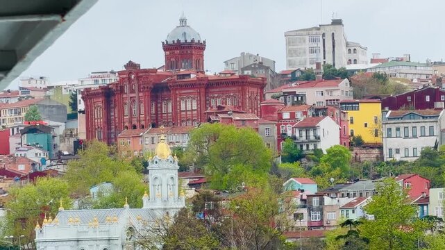 Historic Bulgarian St Stephen Iron Church and Phanar Greek College on Golden Horn coast in Istanbul, Turkey. Ancient orthodox landmarks, old town Balat district architecture and Bosphorus background.