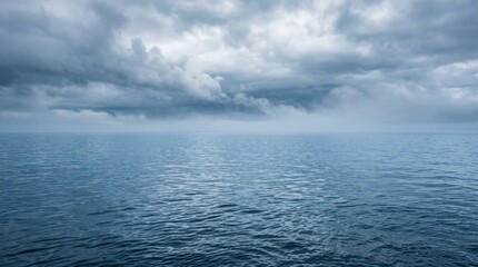 Obraz premium Calm blue sea water with fluffy white clouds in the bright summer sky over the peaceful ocean horizon during the day