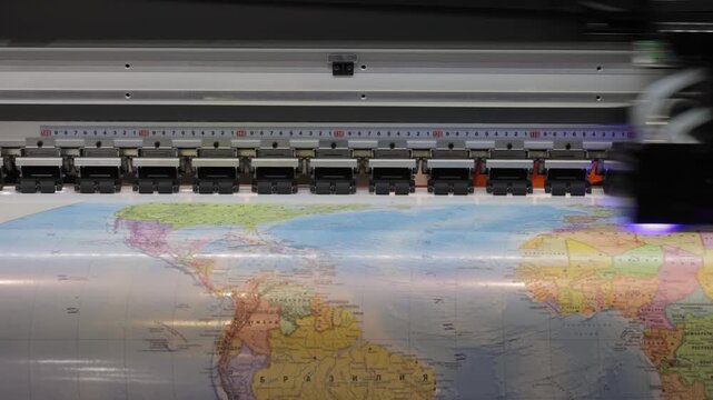 Large format printer creating detailed world map motion graphics footage.