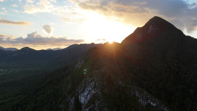 Aerial view of a dramatic mountain ridge at sunset with green screen transition