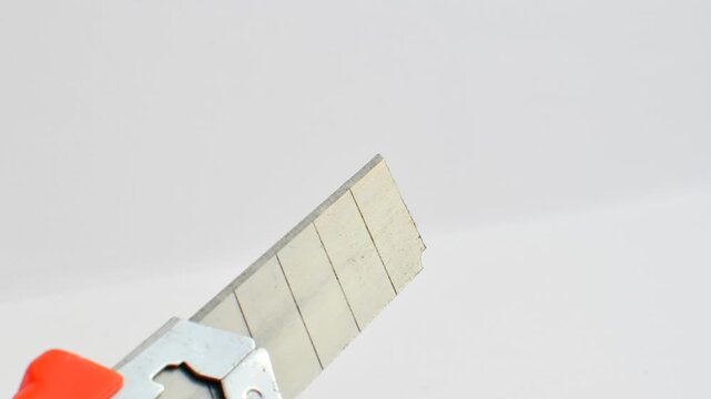 Sharp utility knife on a clear surface, ready for precise cuts for creative projects. Close-up of a stylus on a light background, an essential tool for detailed work.