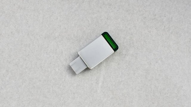 Close-up of an aluminum USB flash drive on a white surface, highlighting design and practicality. Detail of aluminum USB drive on a white background, conveying modernity and efficiency.