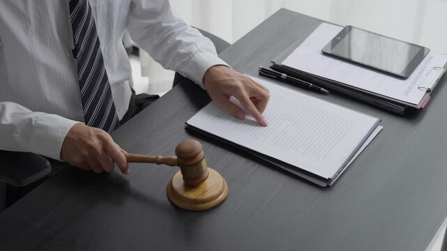 Lawyer using reading legal document and knocking gavel