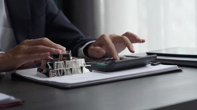 Asian businessman using calculator calculate silver price