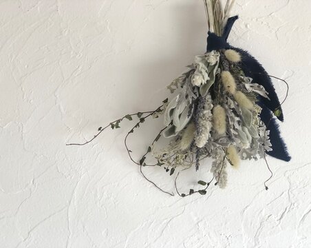 Dried flower swag on white plaster wall with copy space