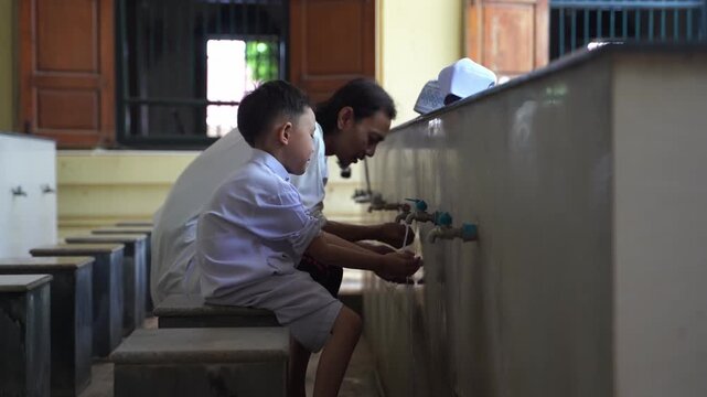 A series of photos showing a heartwarming moment of an adult teaching and helping a young Muslim boy perform Wudu (Islamic ritual purification) at a mosque's ablution area before prayer.