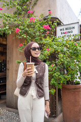 Fototapeta premium Stylish Muslim Woman Drinking Coffee in Bali Indonesia