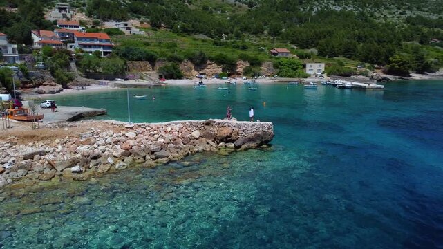 People standing on stone pier in beautiful zavala croatia