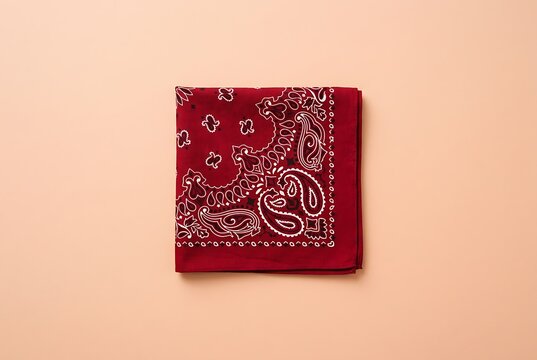 Red Paisley Bandana Neckerchief Folded on Peach Background