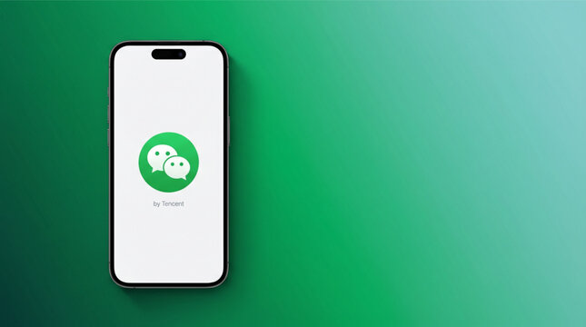 Smartphone iPhone 15 Pro with WeChat app logo by Tencent on the screen displayed against a green gradient background. Mobile communication messaging social network application software interface.