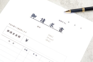 請求書 - 取引先へ宛てて請求書を準備する、ビジネスシーンのイメージ  © PJM