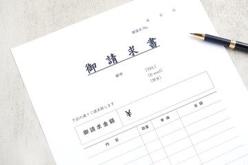 請求書 - 取引先へ宛てて請求書を準備する、ビジネスシーンのイメージ  © PJM